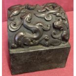 A large square shaped Chinese bronze seal with looped handle featuring mythical creatures.