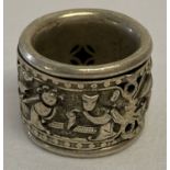 A Chinese white metal Archers ring with decorative central rotating panel featuring.