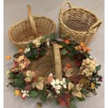 A large basket with autumnal artificial flowers together with a 2 handled log basket and one other.