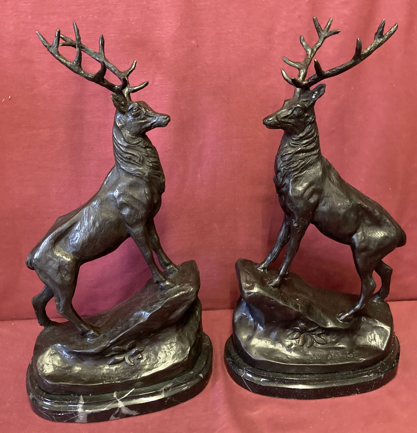 A pair of large marble based bronze figurines of stags.