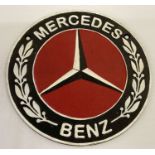 A circular shaped cast metal Mercedes Benz wall hanging plaque.