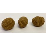 3 small carved spherical shaped oriental figures, possibly from nuts.
