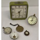 A modern design ball clock together with a vintage green painted alarm clock.