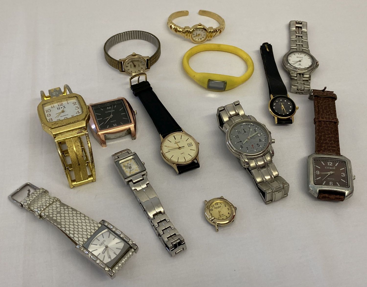 A box of ladies and men's modern wristwatches in varying styles and conditions.