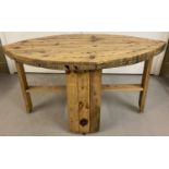 A rustic reclaimed coffee table made from a wooden cable drum.