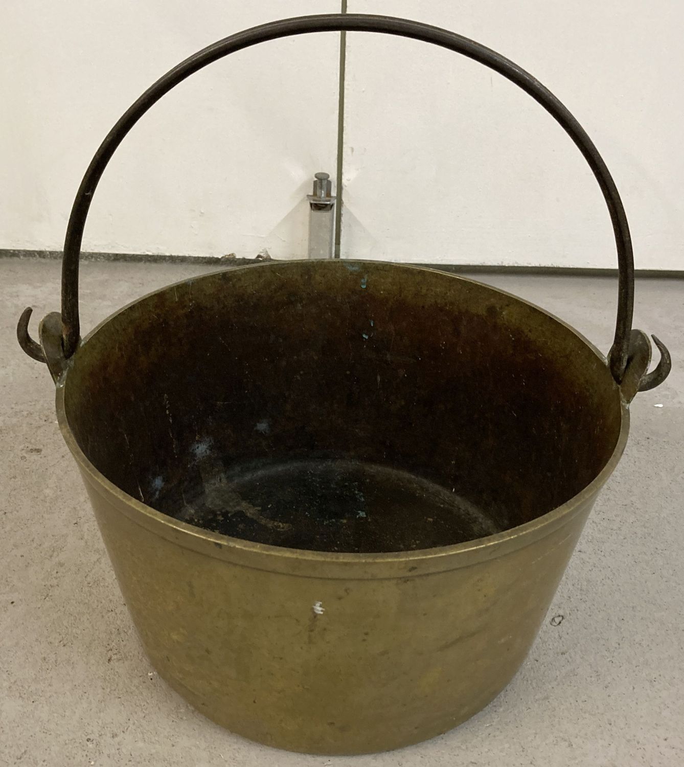 A vintage heavy brass jam pan with carry handle.