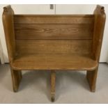 A vintage pine pew seat with central support foot.