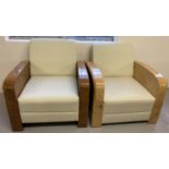 2 Art Deco style armchairs with veneered wooden arms and cream faux leather upholstery.