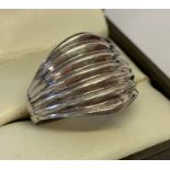 A modern design silver dress ring in a ribbed dome style.