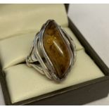 A modern wave design silver ring set with amber, back of mount marked 925.