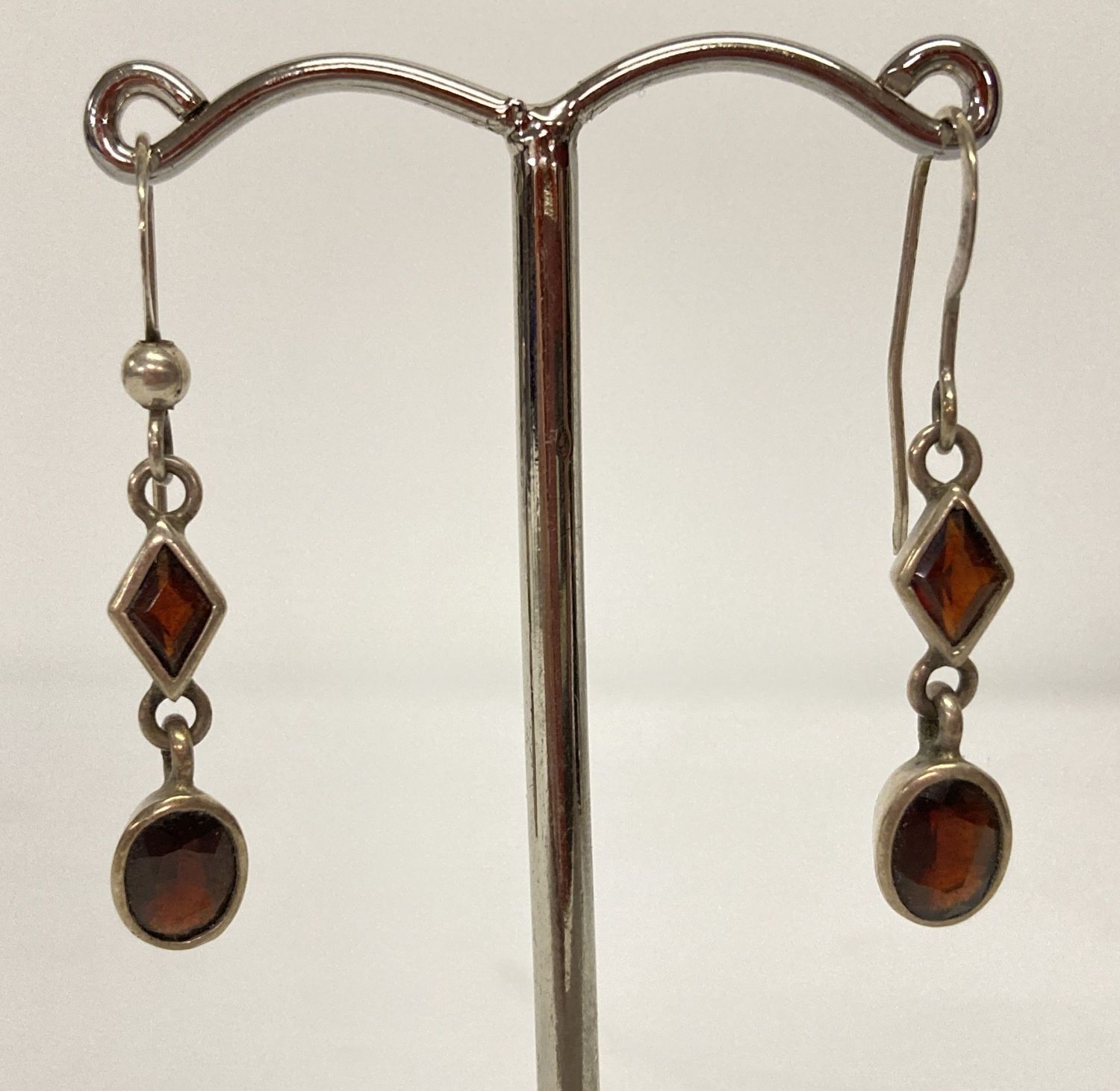 A pair of modern design silver drop earring set with garnets.