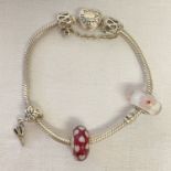 A silver Pandora charm bracelet with heart shaped clasp and 4 charms.