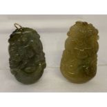 2 carved jade pendants with gold bales, one depicting a horse, the other an ox.