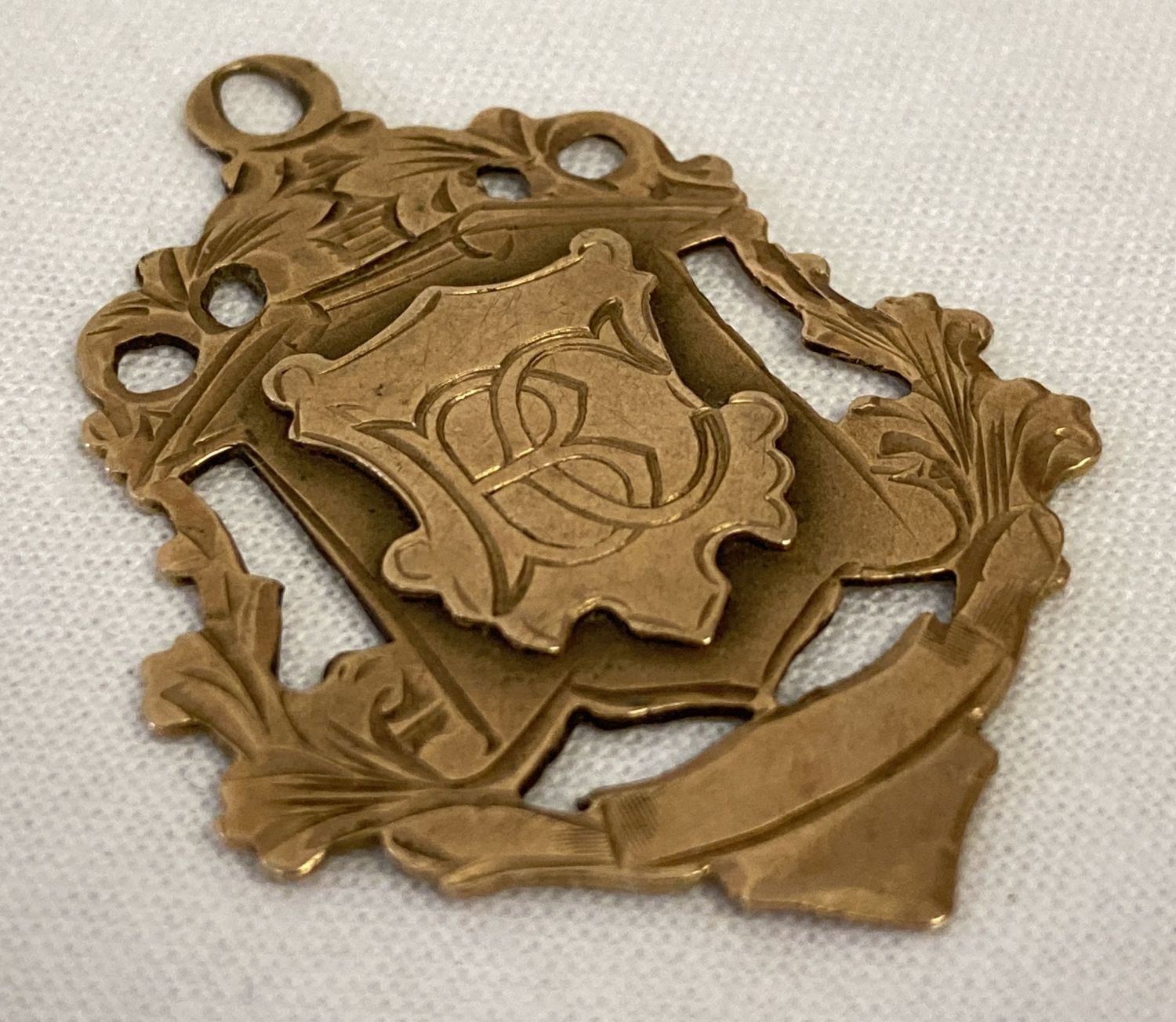 A Victorian rose gold fob in the shape of a decorative shield. Initials BC to front.