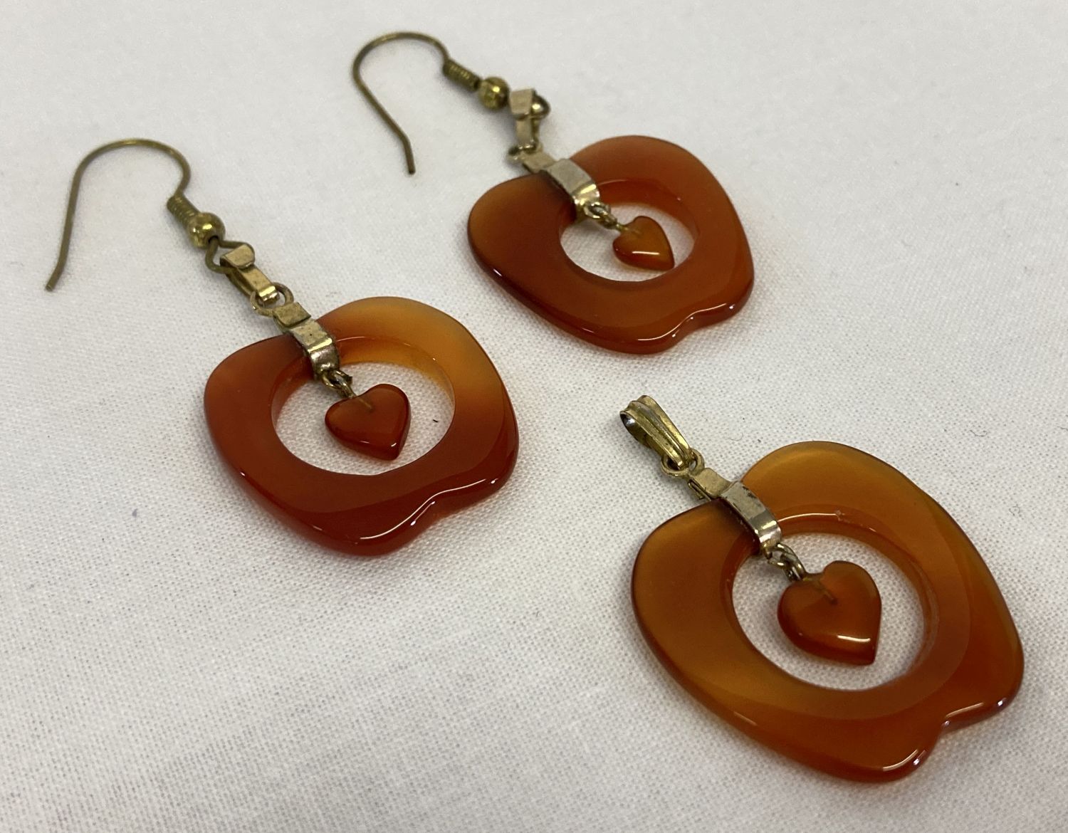 A pair of apple shaped carnelian drop earrings with matching pendant.