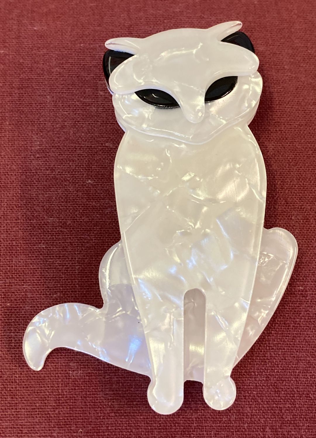 A Lea Stein style black and white pearlised Lucite pin back brooch in the form of a cat.