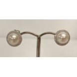 A pair of 18ct white gold, pearl and diamond stud earrings by Luke Stockley London.