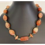 A vintage carnelian and metal bead necklace with silver clasp.