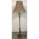 A brass covered standard lamp with Art Nouveau style lotus flower and leaf design to base.