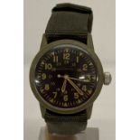 A Vietnam War style plastic cased Special Forces manual wrist watch with green canvas strap.