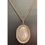 A vintage silver oval shaped locket with floral decoration to front, on a 22" curb chain.