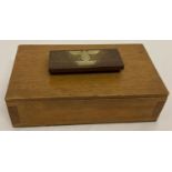 A vintage wooden lidded cigarette/ditty box with brass Nazi Eagle insignia (1939) mounted to handle.