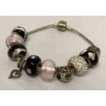 A modern silver charm bracelet and 7 glass and silver beads by Rhonda Sutton.