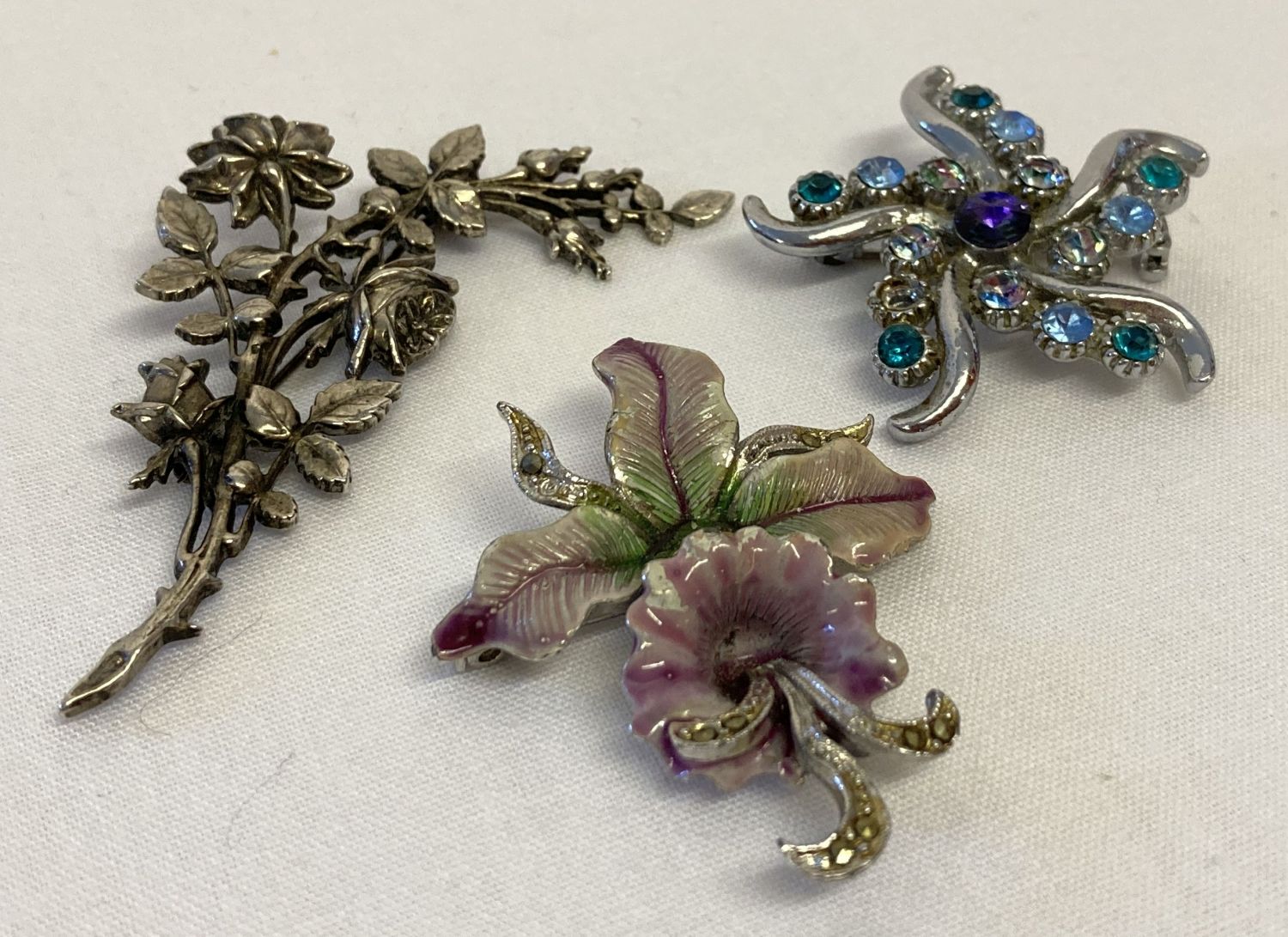 3 floral design vintage costume jewellery brooches.