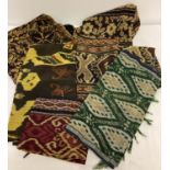 A quantity of hand woven ethnic throws/table cloths and table runners with tasselled ends.