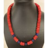 A 19" coral and lapis lazuli beaded necklace with circular shaped beads & gold tone S shaped clasp.