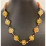 A 17" faceted agate, quartz and red aventurine beaded necklace with white metal T bar clasp.