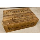 A wooden J. Lyons & Co advertising crate with hinged lid and rope handles.