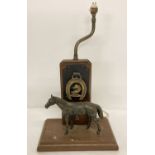A vintage wooden lamp base with horse brass and cast metal horse detail.
