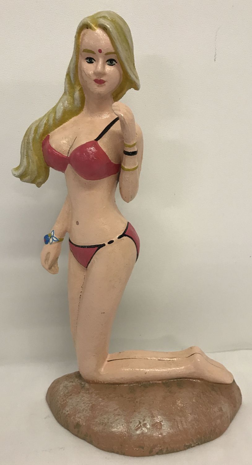 A painted cast metal doorstop in the shape of a bikini clad woman.