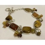 A silver bracelet set with natural stones, agates and pearls by Whitney Kelly, with T bar clasp.