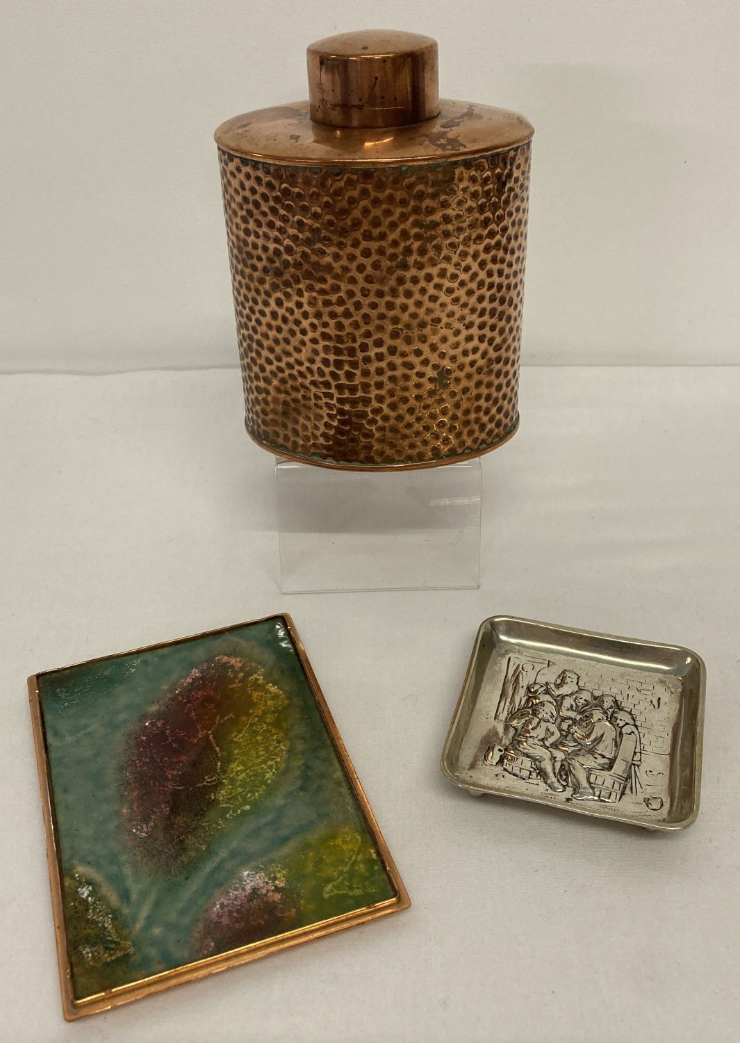 A vintage copper tea caddy with hammered effect decoration.