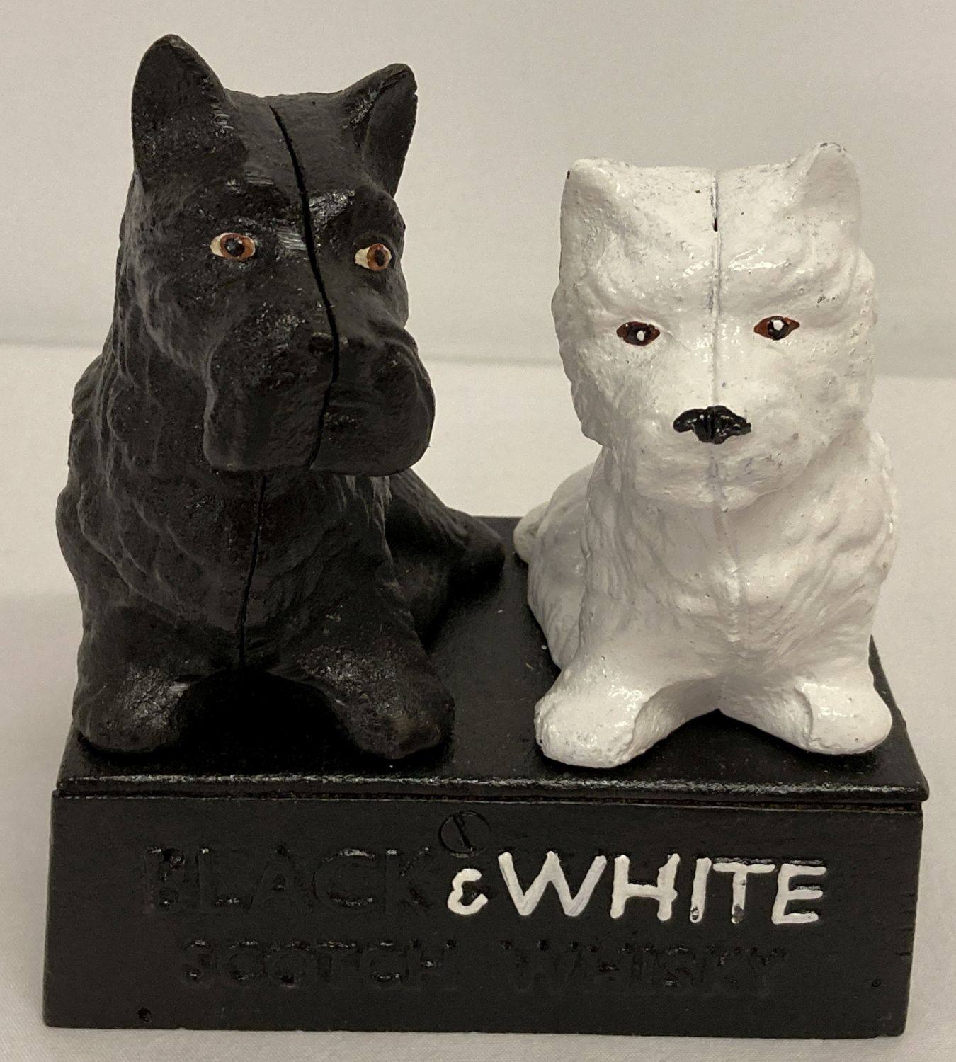 A painted cast iron advertsing stand depicting two Scottie dogs for "Black & White Whiskey".