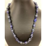 A 20" Lapis lazuli beaded necklace with white metal T bar clasp.