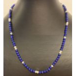 A small lapis lazuli and pearl bead necklace with gold spring style clasp.