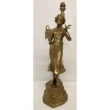 A cast metal lamp base in the figure of a woman holding a basket of fruit with a bird on her hand.