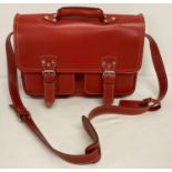A large red leather satchel with white stitching and detachable name and address label.