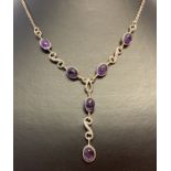 A silver fixed drop pendant style necklace set with oval amethyst cabochon's.