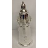 A large silver plated cocktail shaker in the shape of a lighthouse.