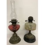2 antique oil lamps. One with cranberry glass bowl and chimney.