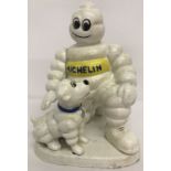 A painted cast iron advertising figure of a Michelin Man and dog.
