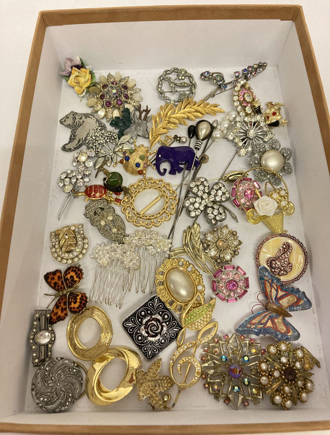 A collection of vintage and modern, brooches, scarf clips and hat pins.