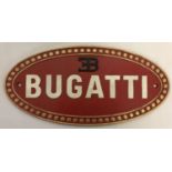 An oval shaped painted cast metal Bugatti wall hanging plaque.
