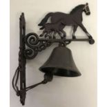 A cast metal wall hanging garden bell with horse and foal decoration.