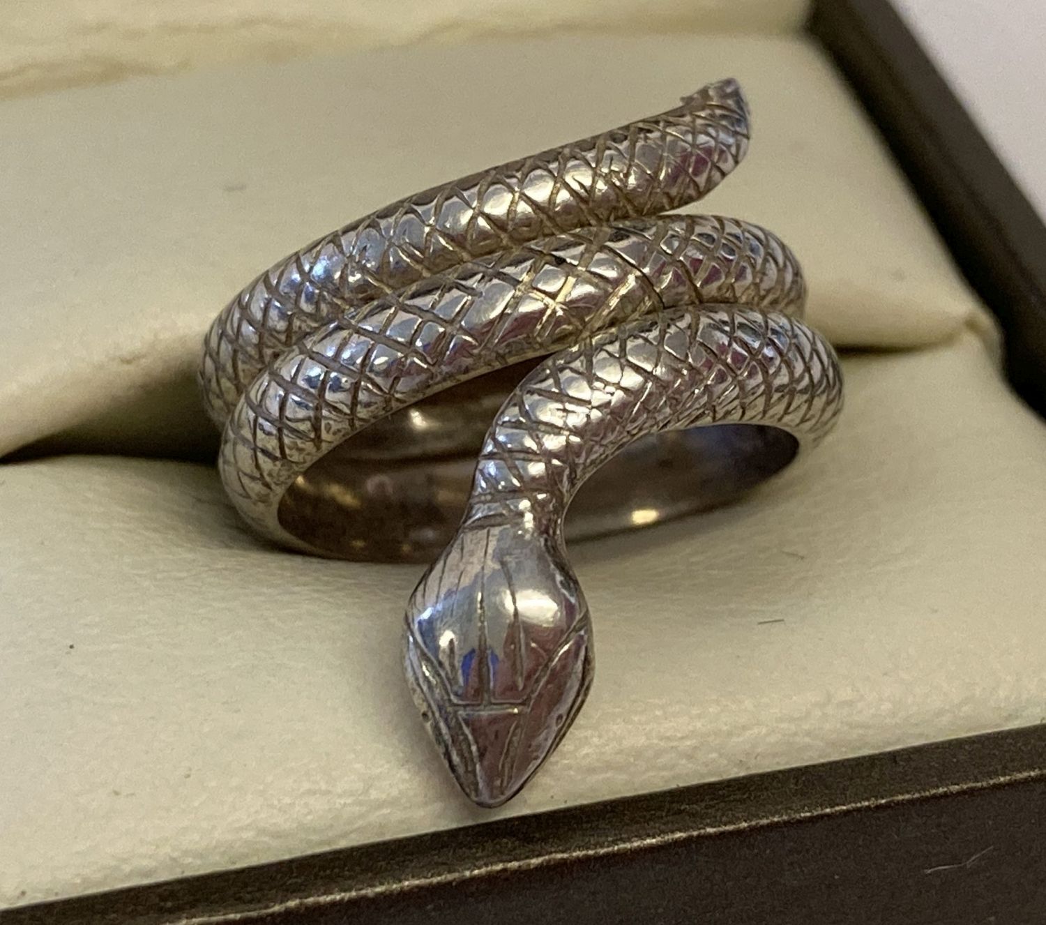 A silver serpent ring with scale decoration throughout.