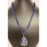 A lapis lazuli bead necklace with teardrop shaped lapis pendant and silver clasp.